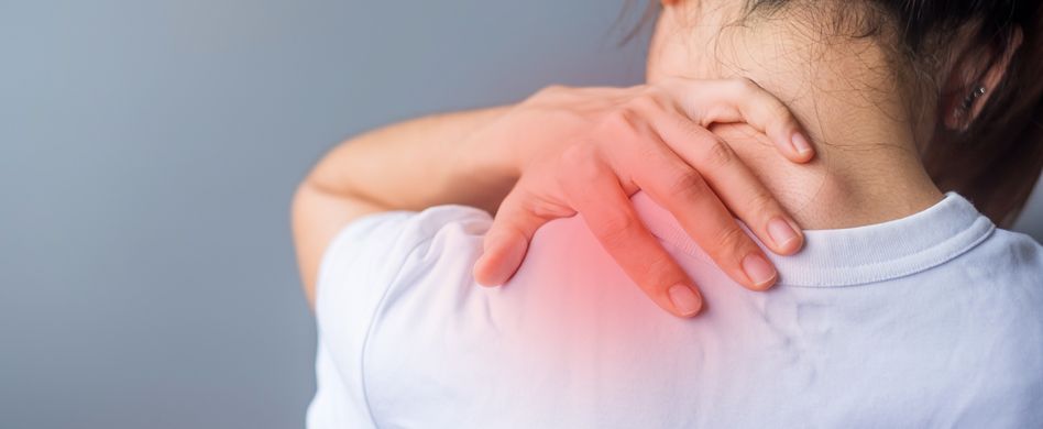 frau im weißen t shirt hält sich die schulter an rot markierter stelle vor schmerzen