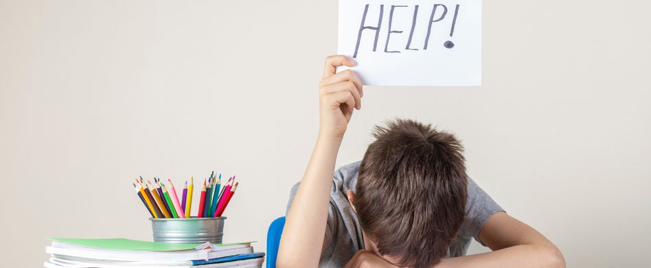 junge mit kopf auf schreibtisch hält schild hoch mit aufschrift help
