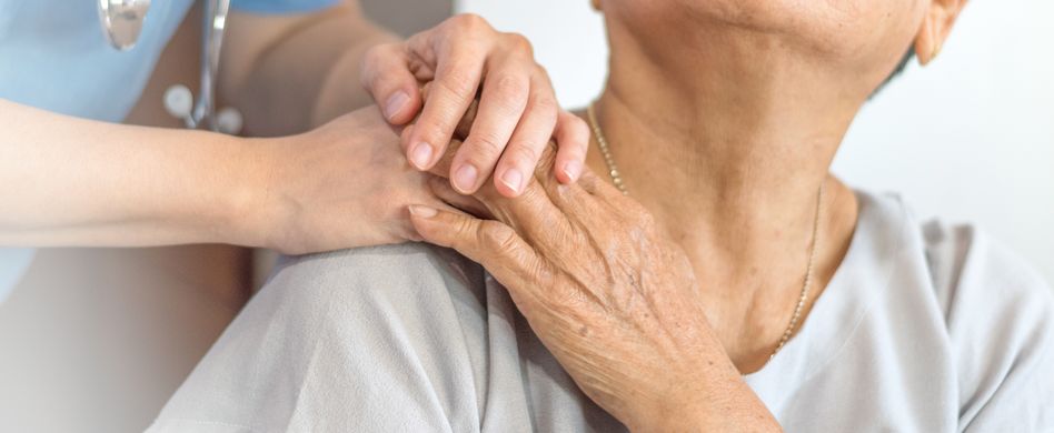 pflegerin oder ärztin hält hand auf schulter von patientin