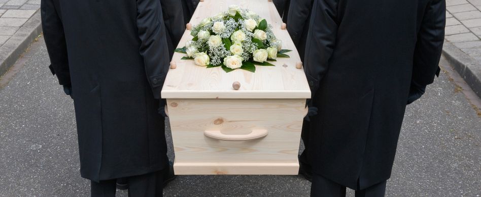 männer in schwarz tragen beigen sarg mit blumen verziert in ein auto