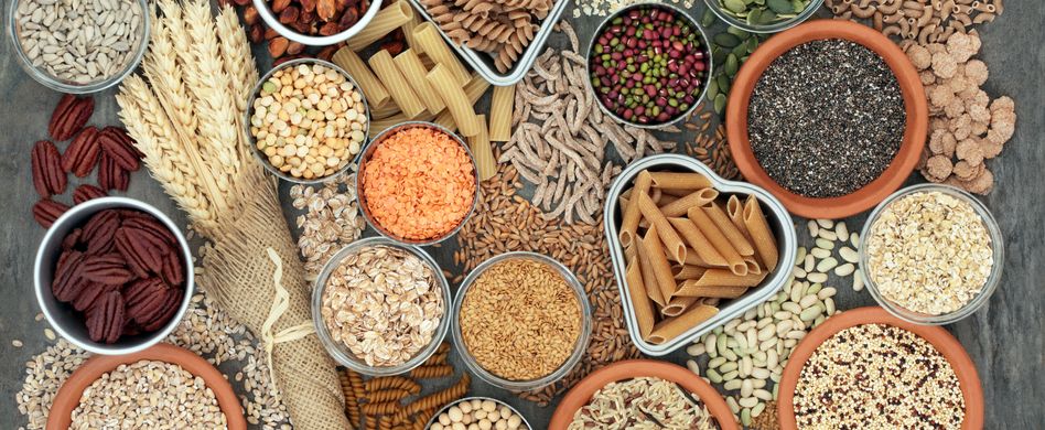 vollkorn und weizenprodukte in runden und herzförmigen schalen auf einem grauen tisch