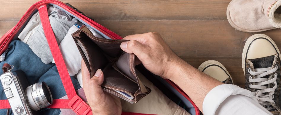 mann mit leerer brieftasche und reisegepäck im hintergrund