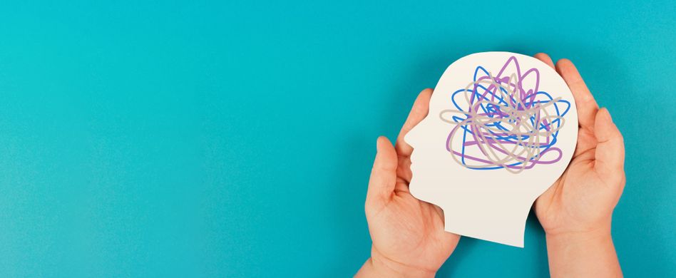 hände halten ausgeschnittenen menschlichen kopf mit linien im innern auf blauem hintergrund