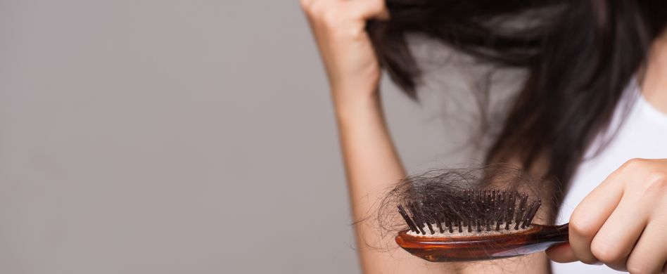 frau verliert schwarze haare in bürste