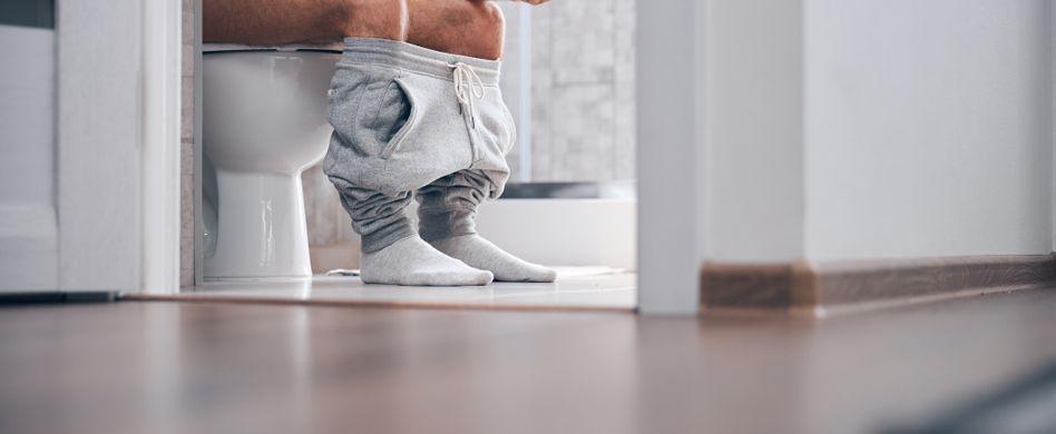 Mann auf Toilette