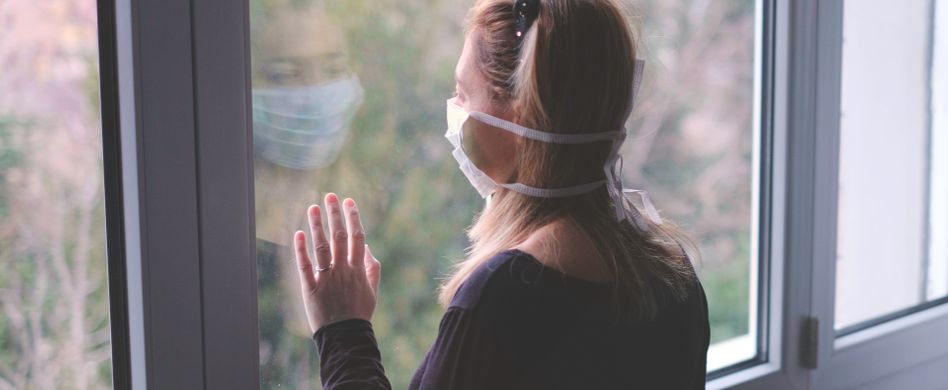 Frau in Isolation an Fenster