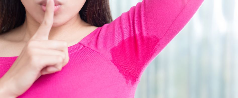 frau mit schweißfleck unter den armen