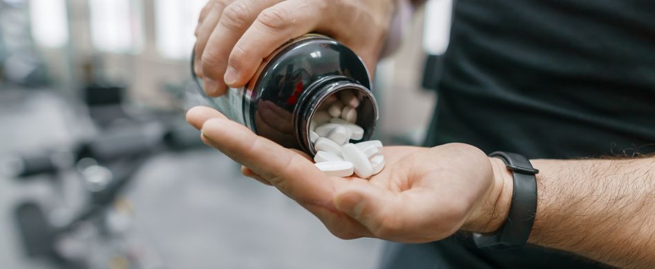 mann nimmt nahrungsergänzungsmittel beim sport