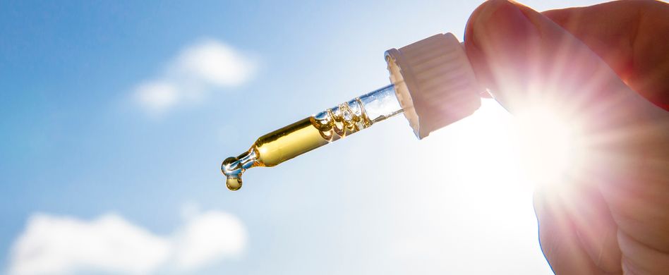 nahrungsergänzungsmittel tropfen vor blauem himmel mit sonnenschein