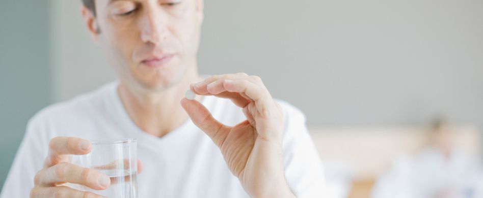 Mann mit Tablette und Wasser