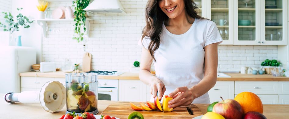 Frau in Küche schneidet Obst