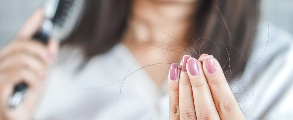 Frau Haare bürsten Haarbüschel in der Hand