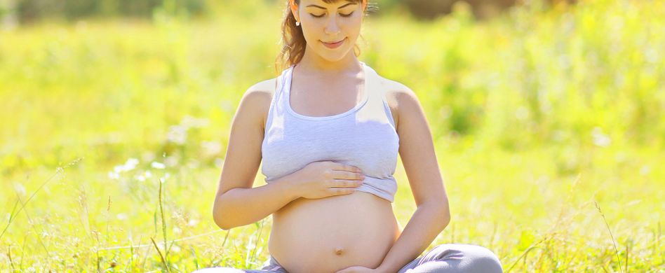 schwangere frau auf grüner wiese