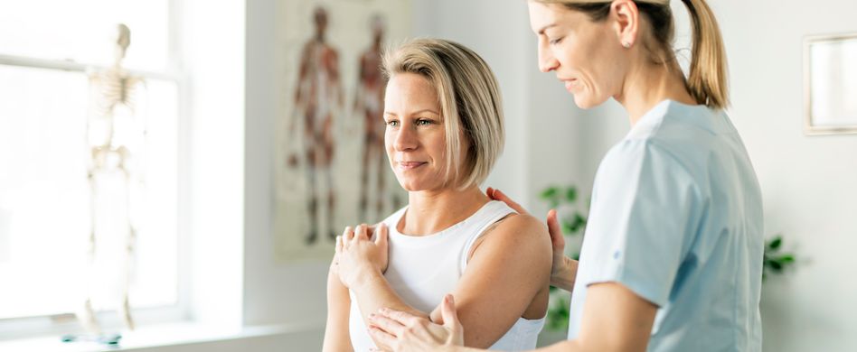 Frau mit Schmerzen in der Schulter bei Arzt
