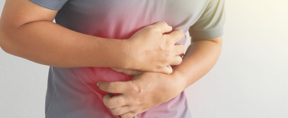 mann hält sich den bauch vor schmerzen