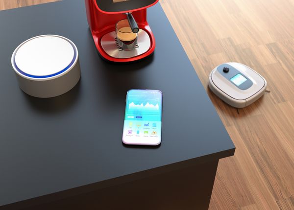 smartphone mit sprachsystem und kaffeemaschine auf tisch