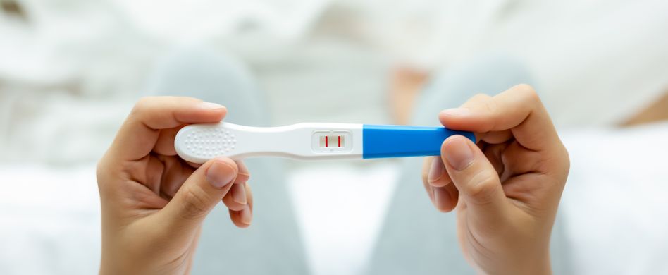 Positiver Schwangerschaftstest ind Händen